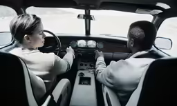 two people sitting in the drivers seat of a vehicle