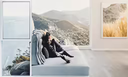 woman resting on couch in large open space with amazing mountain view
