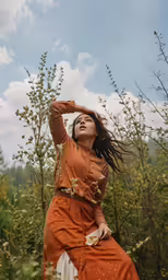 a woman is sitting in the tall grass