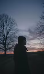 the person is standing outside at night in the winter