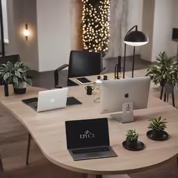 two macbooks open on a desk surrounded by laptops and planters