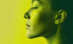 a woman has a green and yellow light reflecting off her face