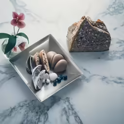food items placed in a square metal container on marbled counter top