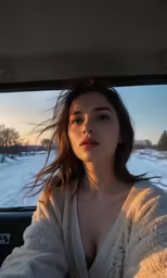 the woman is in the car on the road with snow