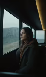 the young woman is looking out the window