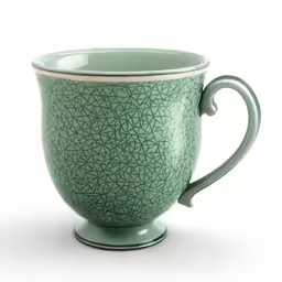 a green and beige cup is set on a saucer