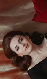 a young woman is laying on the ground with a red pillow