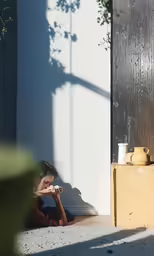 a woman sitting on the ground with a cell phone in her hand
