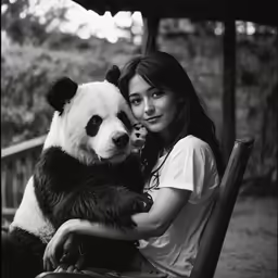 a black and white photo of a woman with a panda