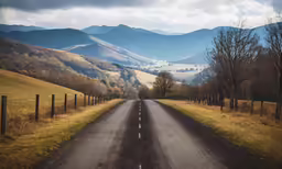 a road going through a countryside with hills in the background
