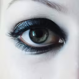 a close up of an eye with a small amount of dark eye shadow