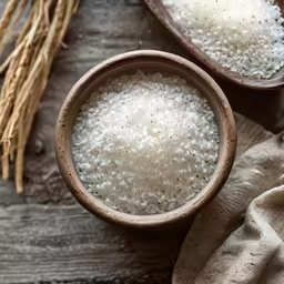 small bowls of cooked white rice on top of a wooden table