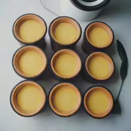 nine jars filled with yellow and brown cream