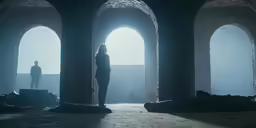 a man standing in front of a doorway with two arched doorways