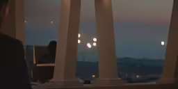 a person sitting in front of a tall window next to columns