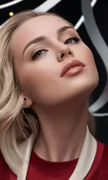 a blonde model in a maroon blouse with her eyes closed and a black and white background