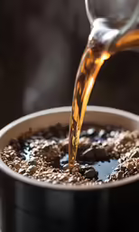 a person pouring tea into a white cup