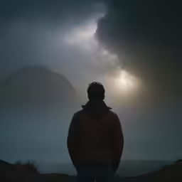 a man watching the sun through a cloudy sky