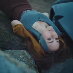 a woman leaning on top of a car