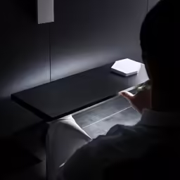 man working on a white laptop computer next to his desk