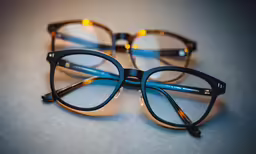 two pairs of glasses sitting next to each other