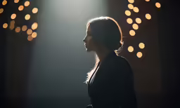 woman standing at a microphone in front of a set of lights