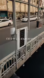 a train crossing a busy city street in the middle of the day