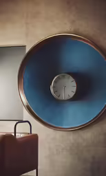 a clock sitting on the wall above a luggage case