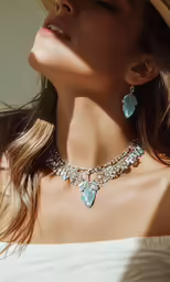 the white dress is wearing an elaborate necklace and earrings