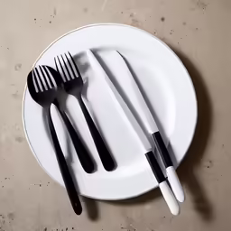 a couple of black and white forks on a plate