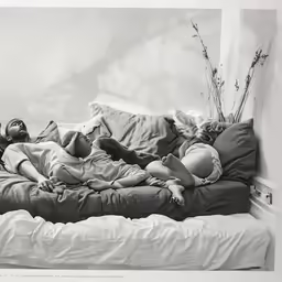 three women sleeping in a bed together on top of each other