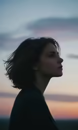 a young woman looks at the sky in this artistic photograph