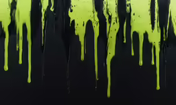 black and green paint dripping over a wall
