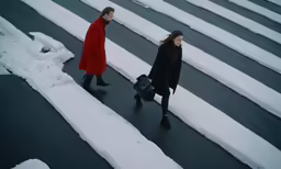 a man and woman walking on street covered with snow