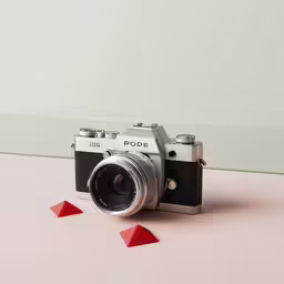 an old fashioned camera next to red triangulars