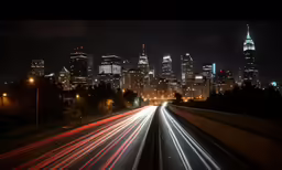 street lights streak through a city skyline at night