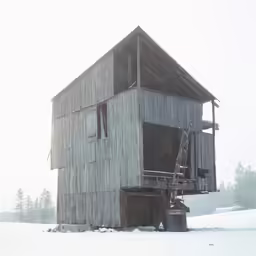 a tall building sitting in the middle of a snow covered field