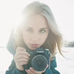 woman with a camera standing in the snow