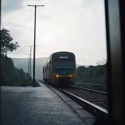 a train traveling down tracks through rural countryside