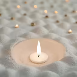 a candle sitting in the middle of a quilt