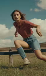a young lady squatting on a wood fence