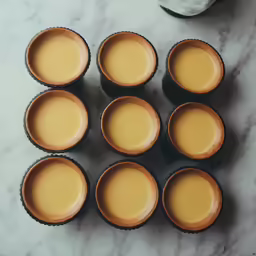 several cups and a bottle are on the table