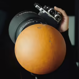a person holding a large ball and camera