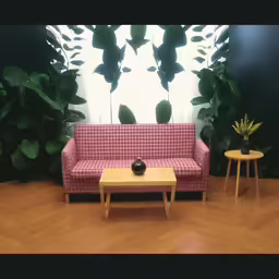 a pink couch and two tables in front of a white wall