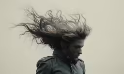 a woman has her hair in the wind