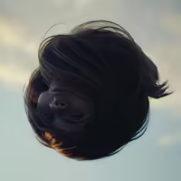 a girl with long black hair looking into the camera