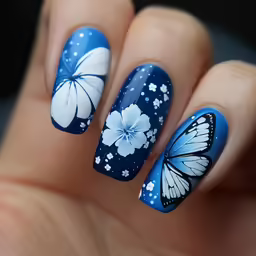 a woman with blue nail polish with white butterflies