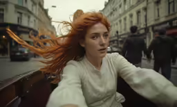 a woman with long red hair walking in the street