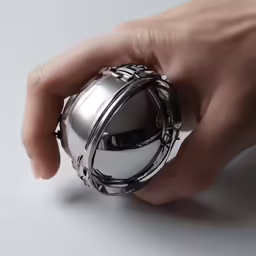 the hands hold a round object near a small white object