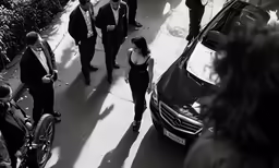 a group of business people in suits and ties walking near an umbrella